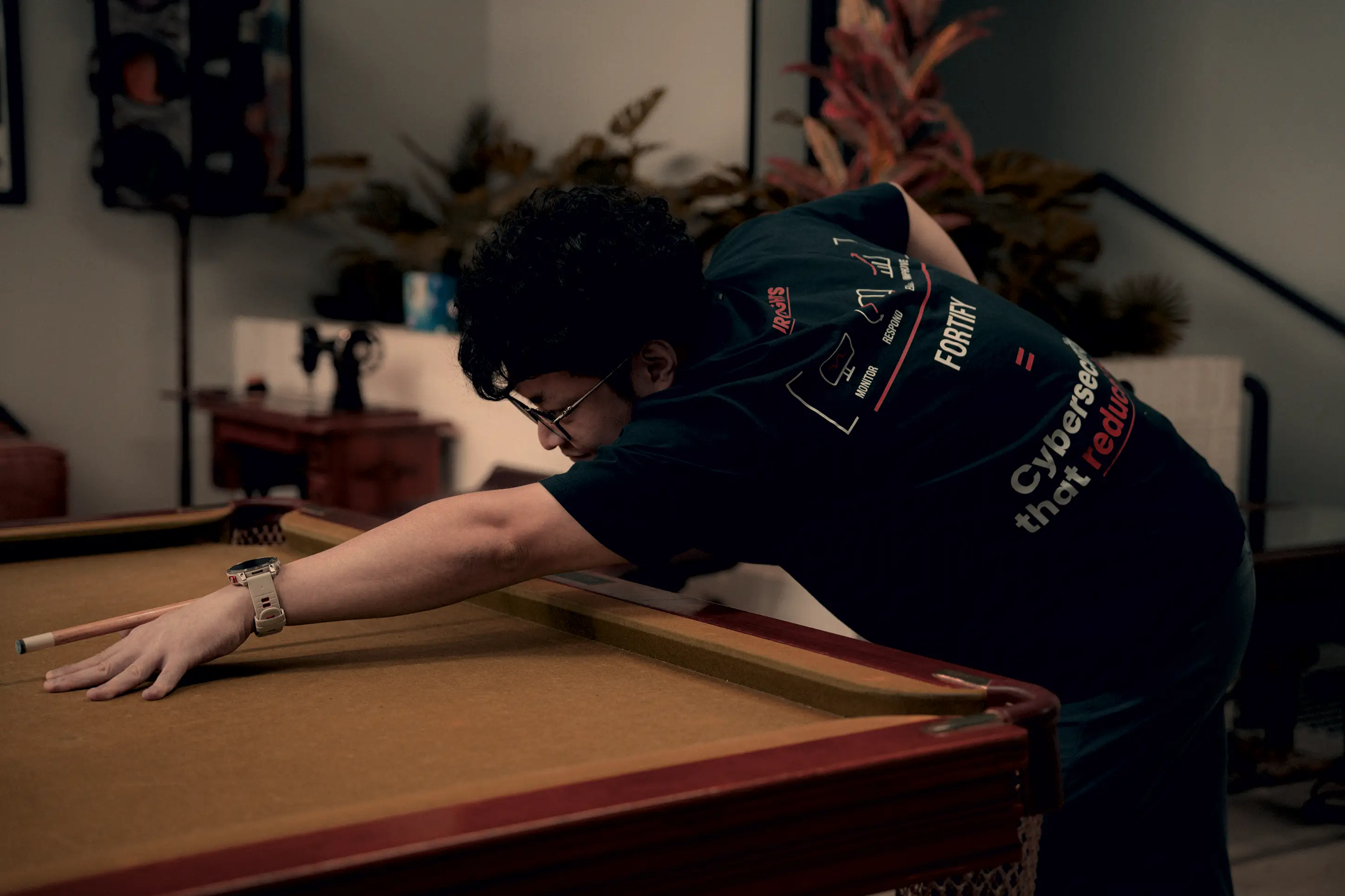 An IronSights team member lining up a shot on the pool table at the Sydney office
